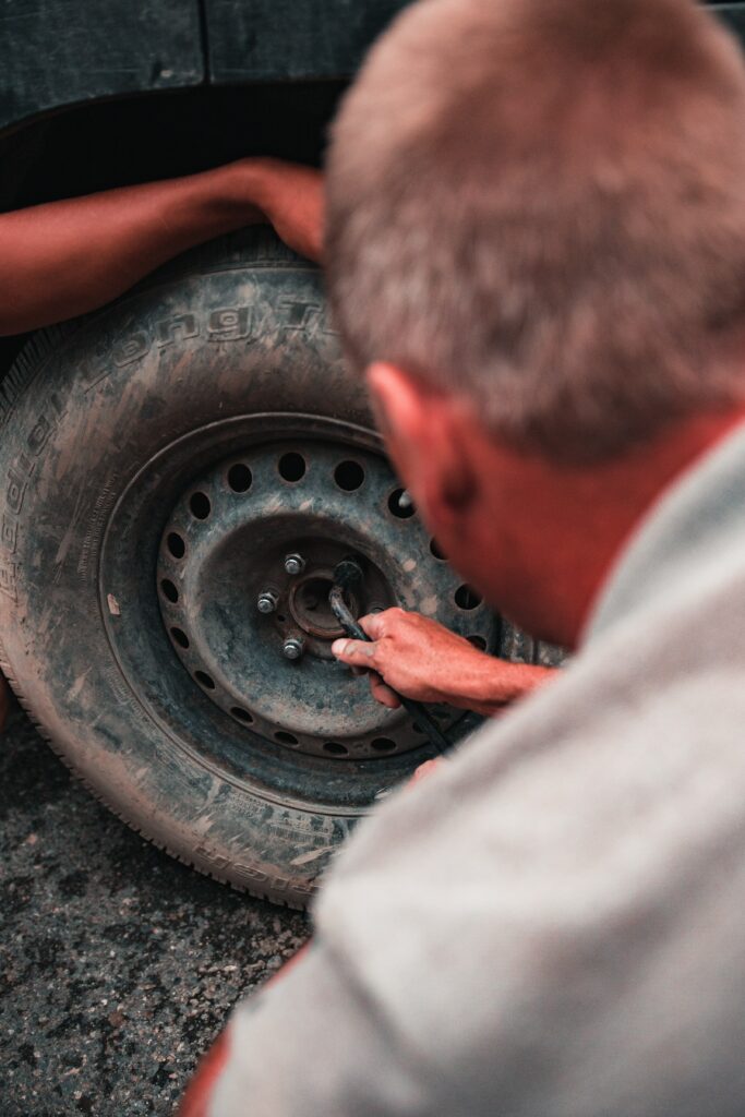 A man changing tyre of a car