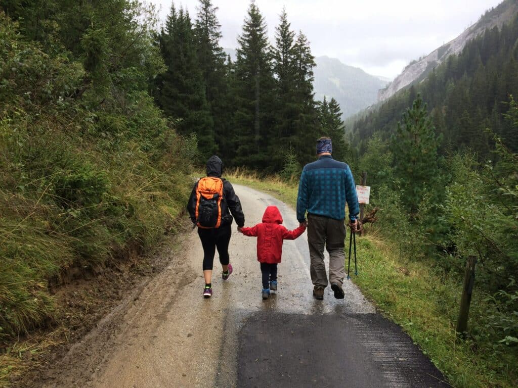 A man along with his spouse and child walking on a road