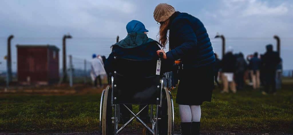 a girl on wheel chair talking to a standing girl indicating guardianship
